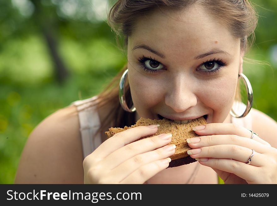 She hungrily eats toast green background