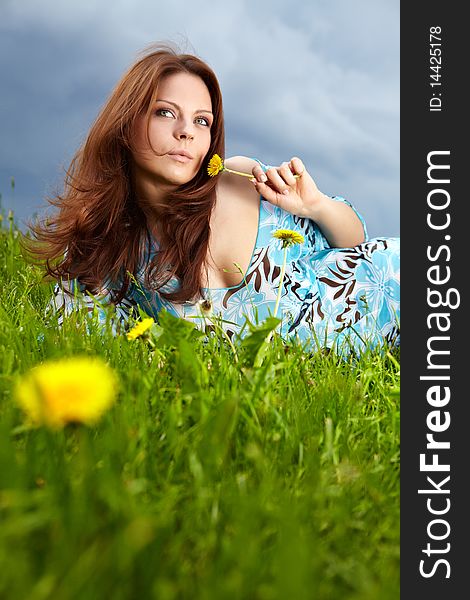 Beautiful young woman on field in summer