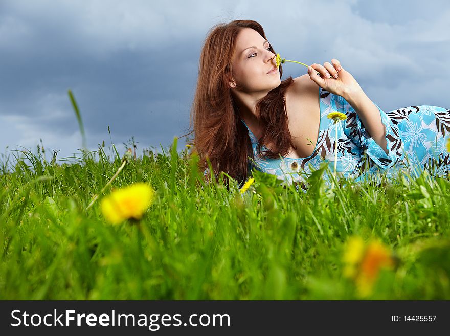 Beautiful young woman on field in summer