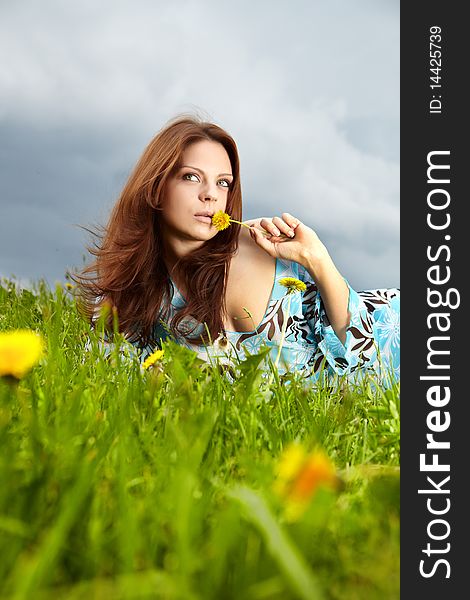 Beautiful young woman on field in summer