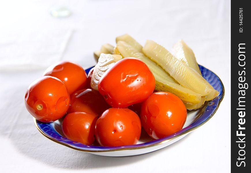 Salted tomatoes and pickled cucumbers on plate