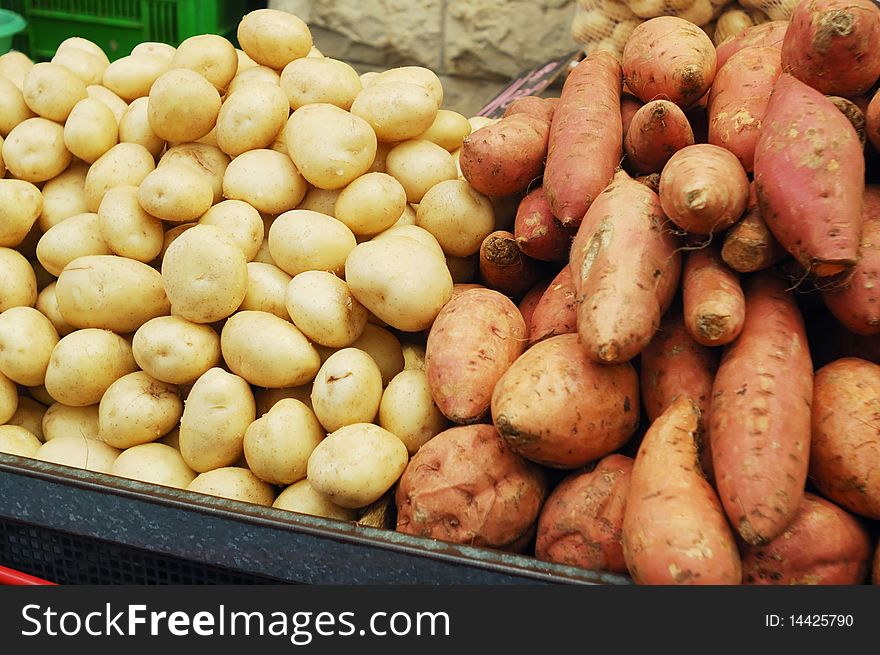 Close up of white and sweet potatoes on market stand. Close up of white and sweet potatoes on market stand