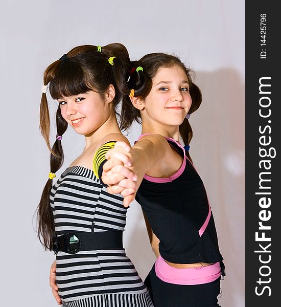 Two fun teen girls on grey background