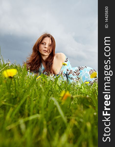 Beautiful young woman on field in summer