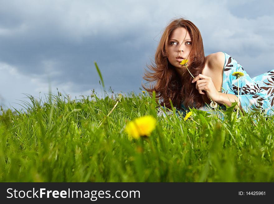 Beautiful young woman on field in summer