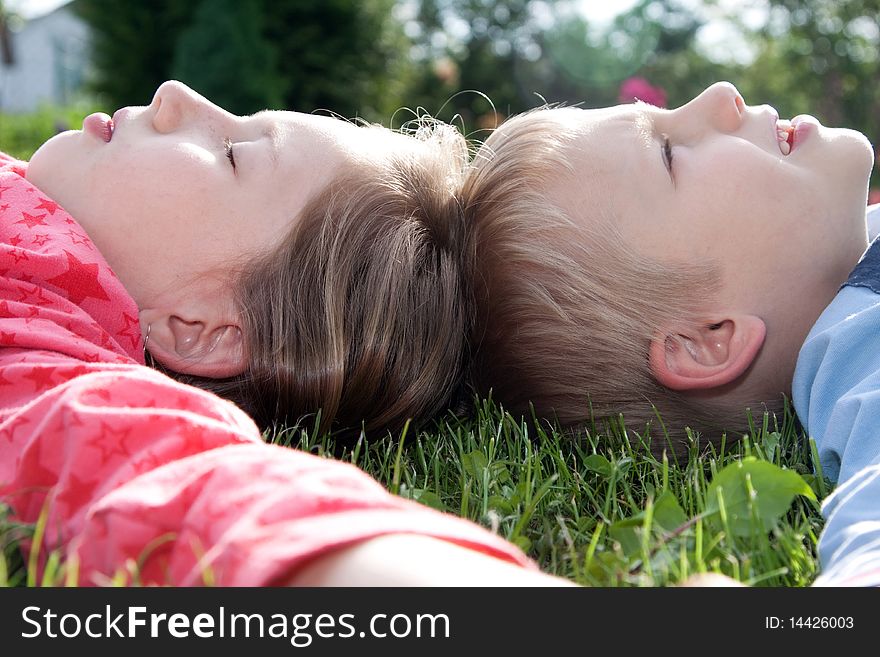 Boy and girl laying on grass