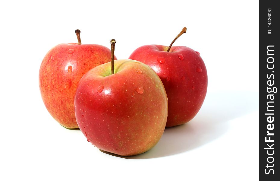 Three red apples with water drops isolated over white