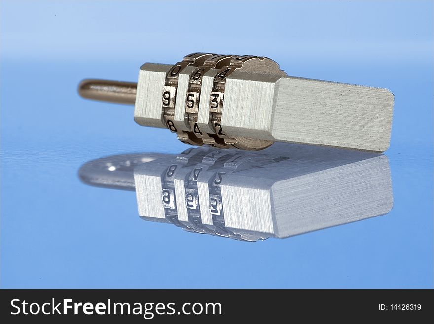 Numeric metal lock with reflection - detailed, close-up view on blue background. Numeric metal lock with reflection - detailed, close-up view on blue background