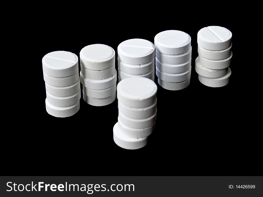 Columns of white pills isolated on black background