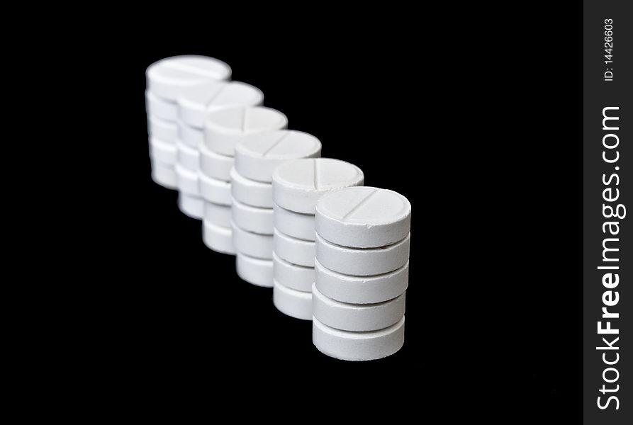 Columns of white pills isolated on black background