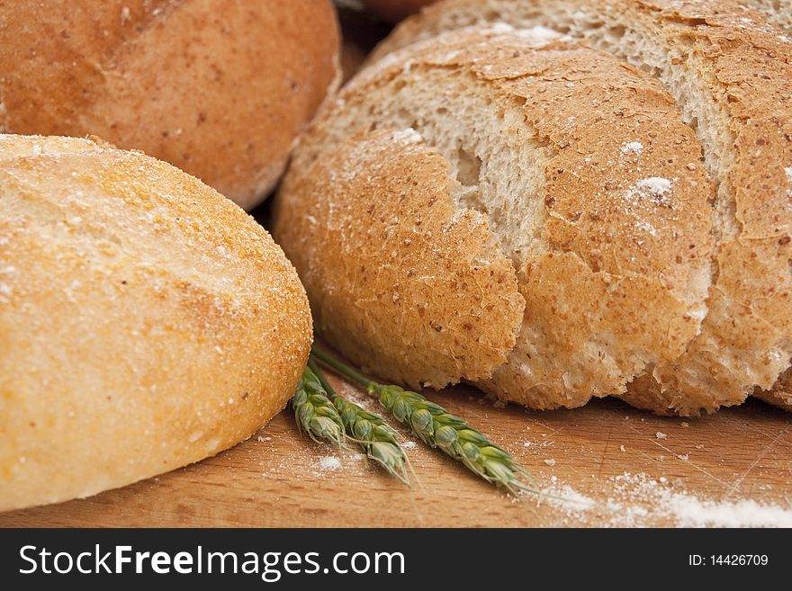 Close up of different types  bread on a wooden board sprinkled with flour