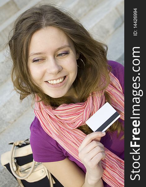 A woman holds in her hand a plastic card for purchases