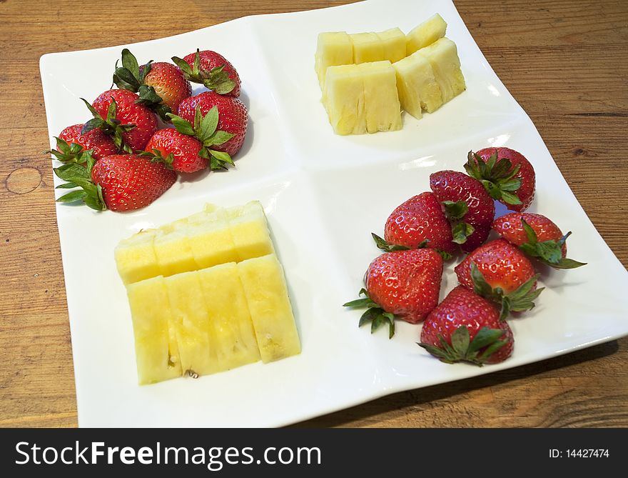 A fruit platter consisting of freshly cut pineapple and strawberries. A fruit platter consisting of freshly cut pineapple and strawberries.