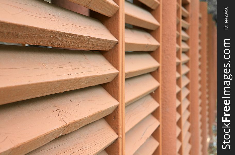 Tan wood and steel slated fence in perspective. Tan wood and steel slated fence in perspective