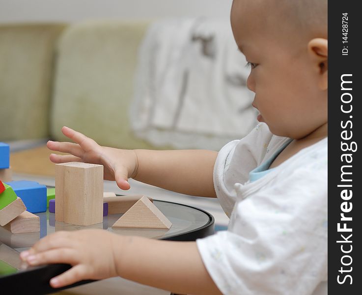 A child is playing with wooden toy blocks.