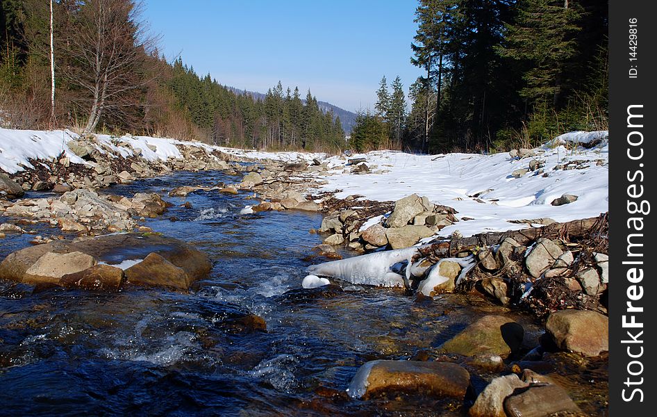 Small river in a winter landscape with woody coast. Small river in a winter landscape with woody coast