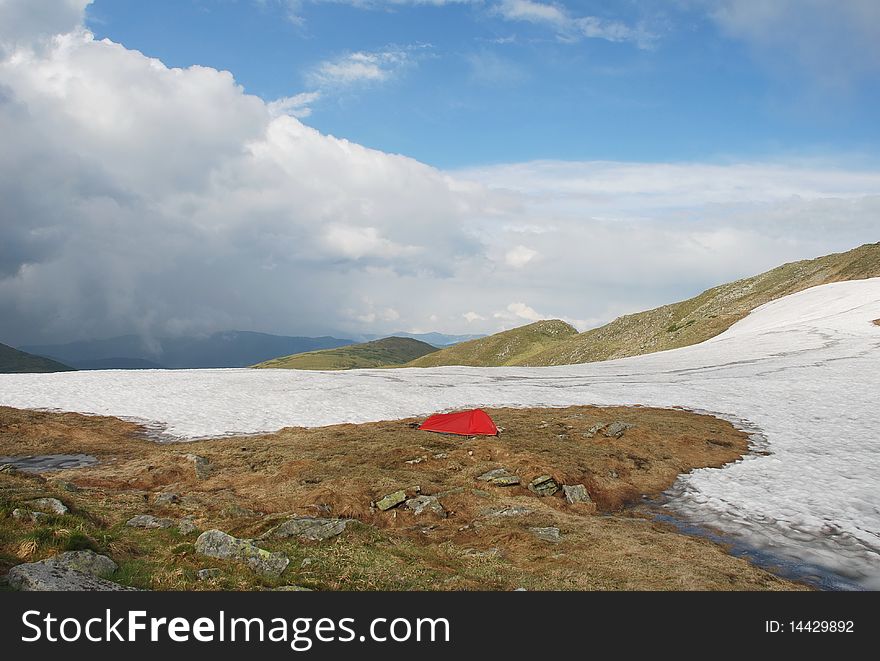 Lonely tent in a mountain spring landscape with clouds. Lonely tent in a mountain spring landscape with clouds.