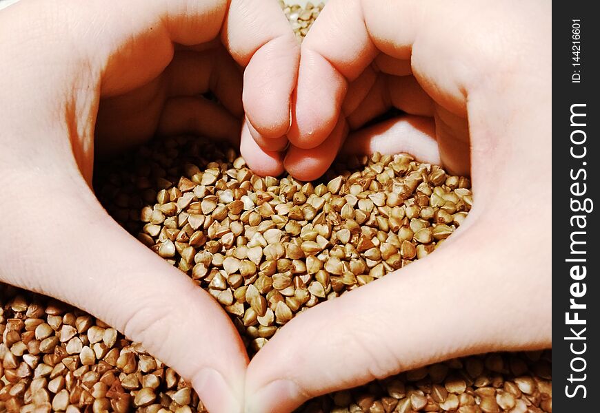Heart-shaped hands on buckwheat.