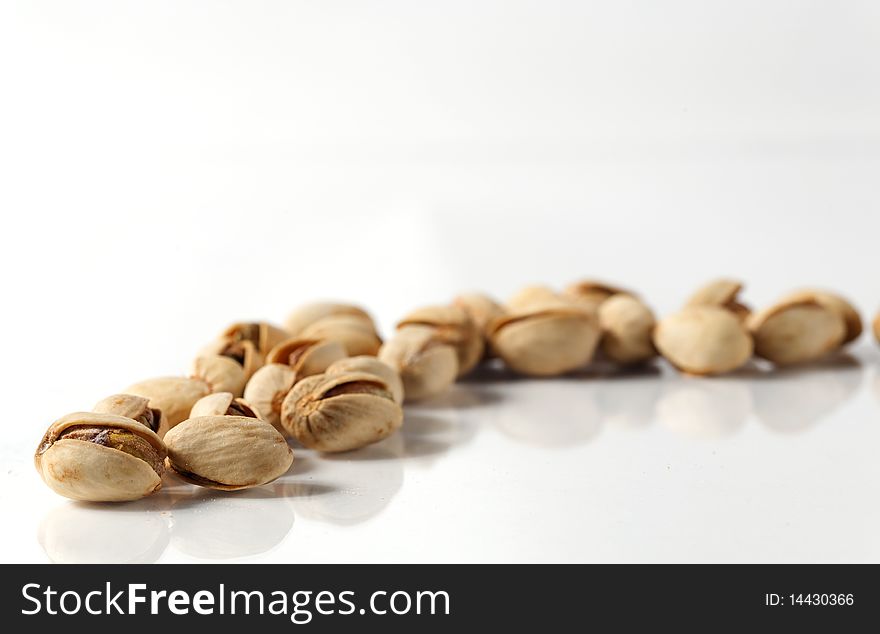 Row of pistachios on a white background