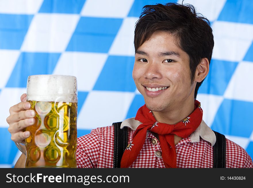 Smiling Asian holds Oktoberfest beer stein (Mass)