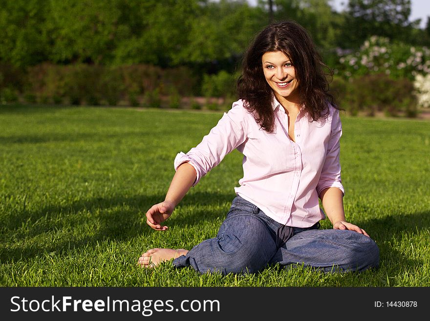 Happy young woman sitting on grass