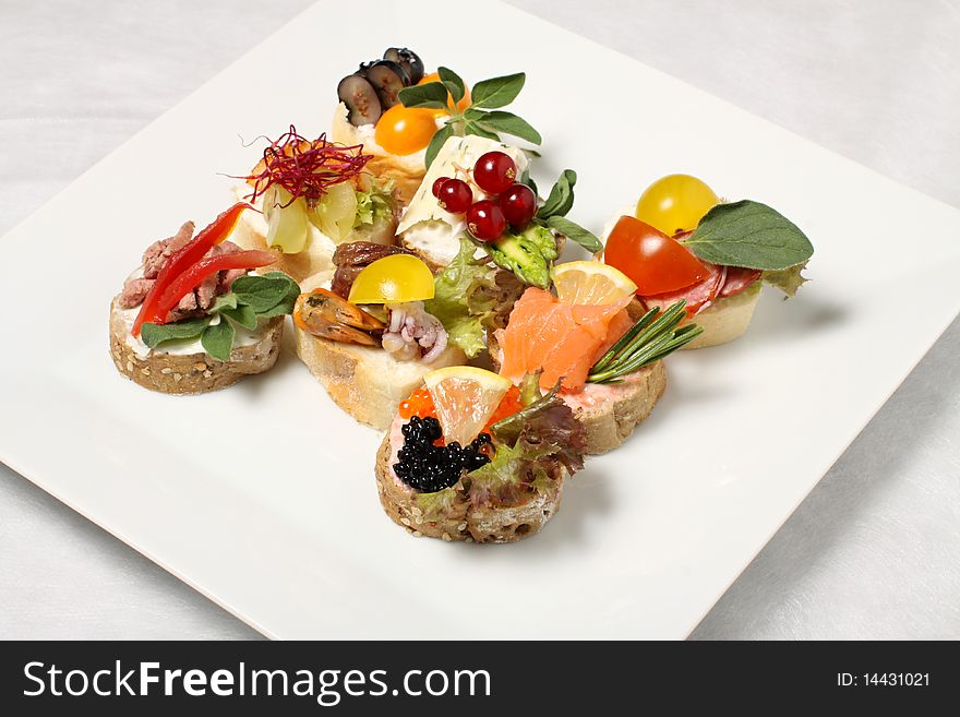 White plate with eight pieces of canapes. White plate with eight pieces of canapes