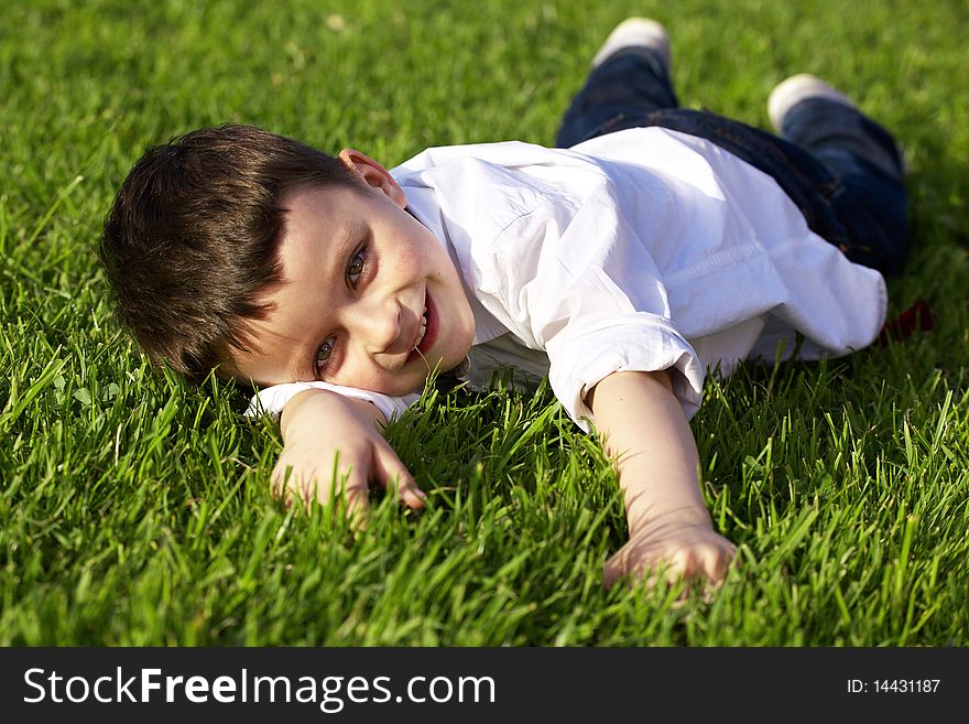 Little boy lying on grass