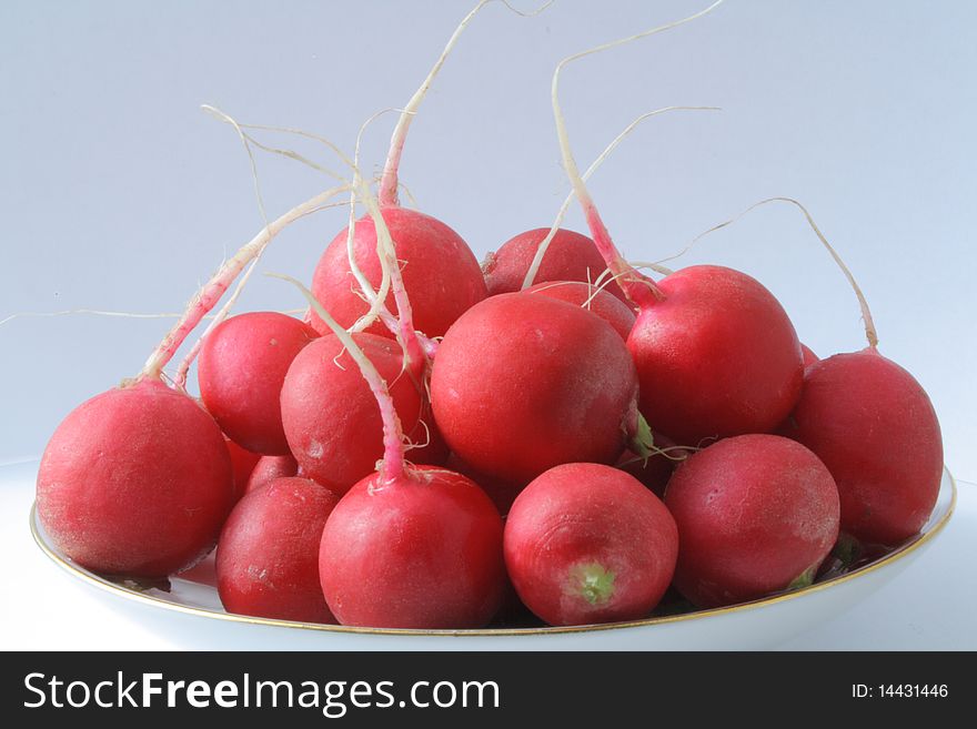 Some pink radishes on a blue background, radishes washed on a plate,. Some pink radishes on a blue background, radishes washed on a plate,