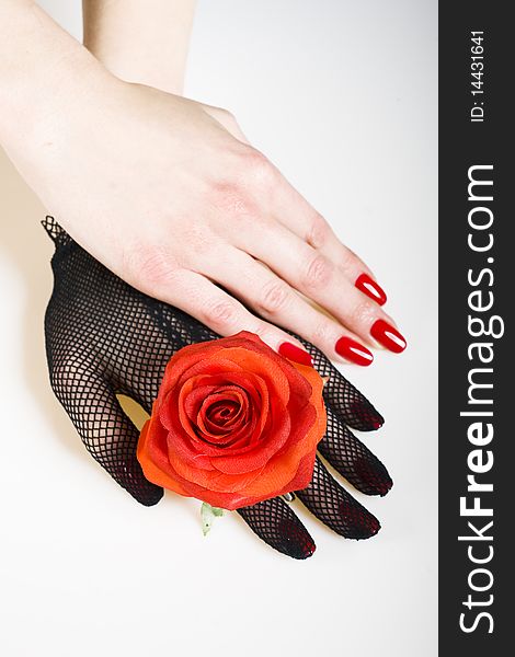 Beautiful hand with perfect nail red manicure, rose and black retro glove