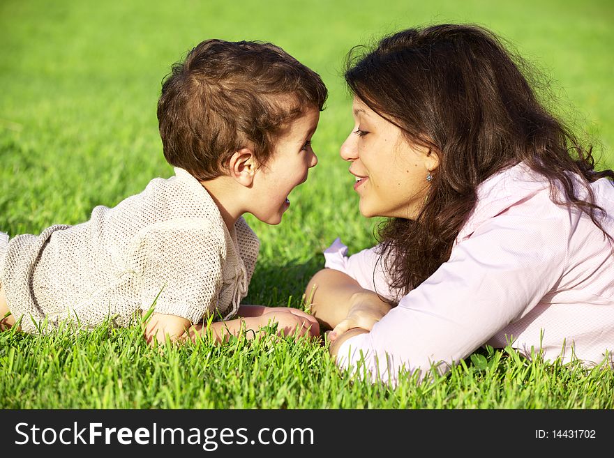 Happy young mother playing with her son outdoor