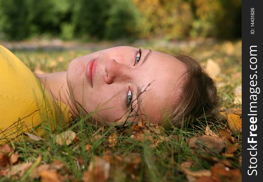 The smiling girl lays on a grass