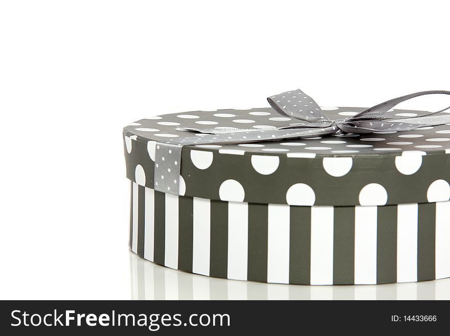 A grey white striped dotted round giftbox isolated over white. A grey white striped dotted round giftbox isolated over white