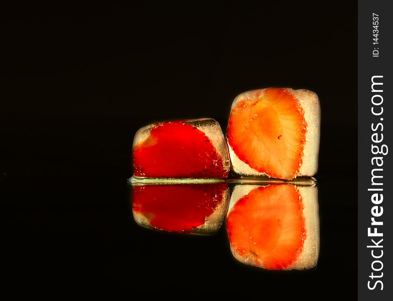 Strawberry in the ice on black background