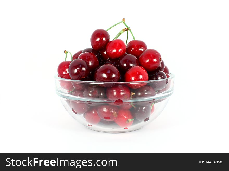 Heap of sweet cherries in a glass bowl isolated on white