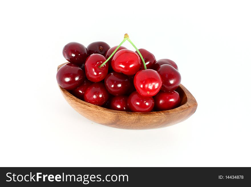 Sweet cherries in a wood bowl, isolated on white