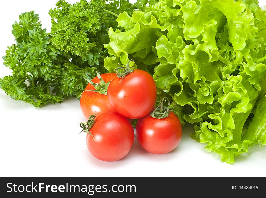 Tomatoes with salad and parsley on a white background