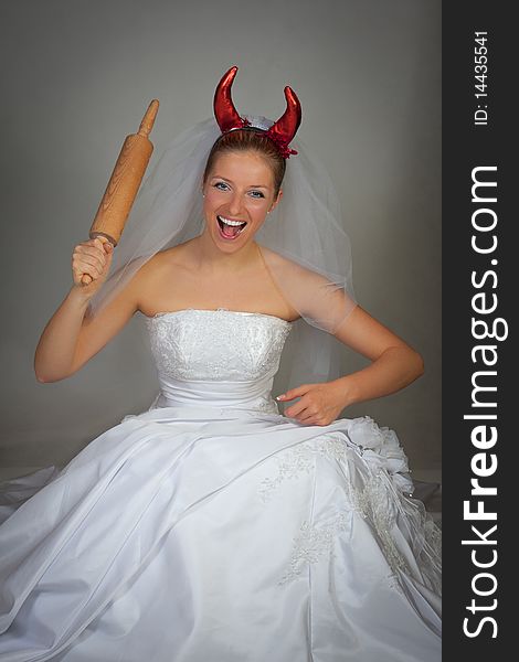 Bride in wedding dress wearing devil horns. Bride in wedding dress wearing devil horns