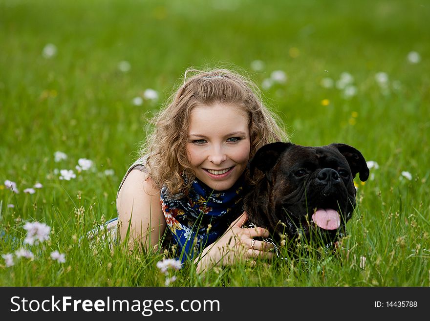 Young girl lay in the grass outdoor smiling with dog