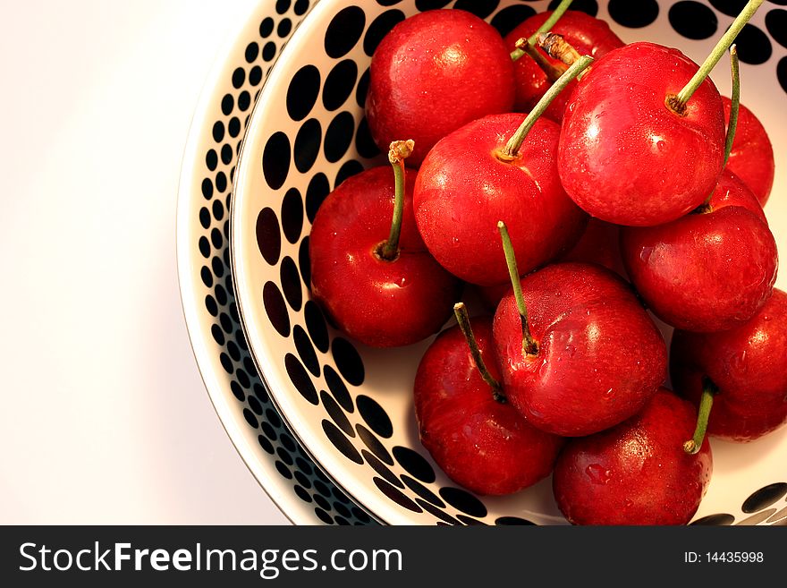 Fresh bright red cherries in black and white bowl. Fresh bright red cherries in black and white bowl