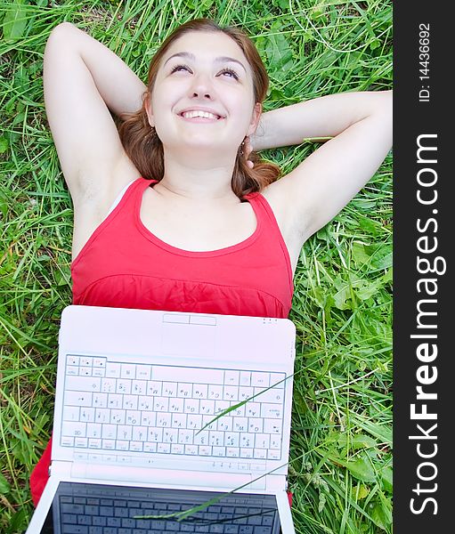 Beautiful attractive young girl on nature with laptop
