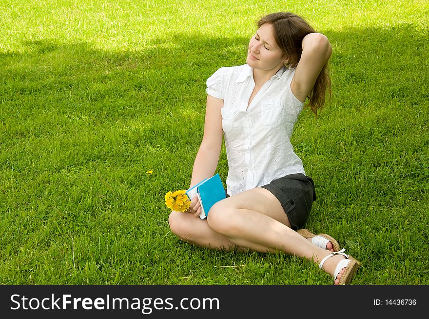 Attractive woman is getting  pleasure from resting with book in park. Attractive woman is getting  pleasure from resting with book in park