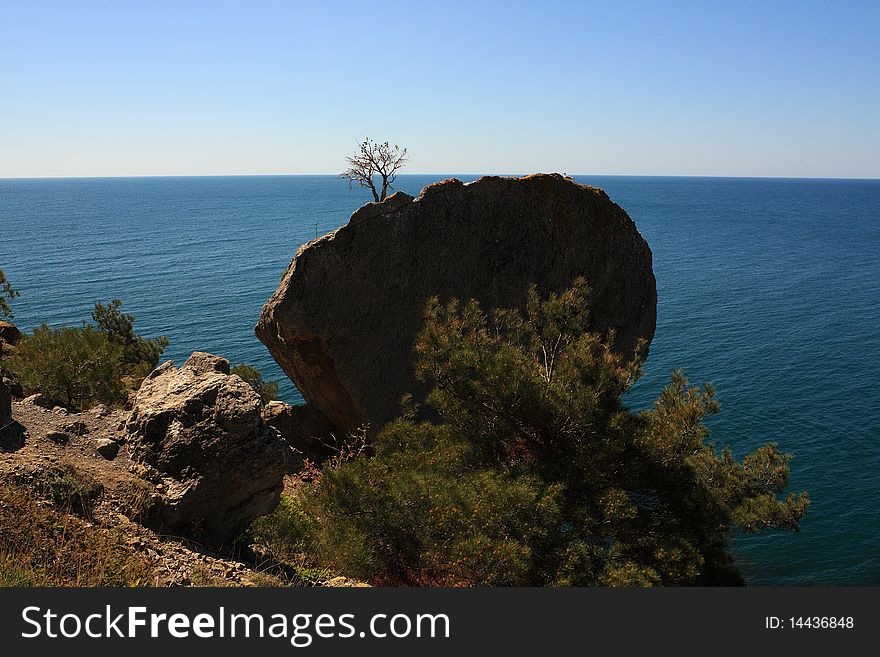 Mountain and sea landscape east of crimea. The mountains and rocks, covered with juniper and pine. Blue sea. Mountain and sea landscape east of crimea. The mountains and rocks, covered with juniper and pine. Blue sea