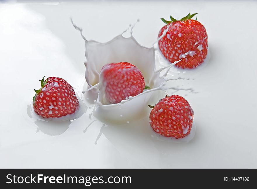 Strawberries splashing in milk