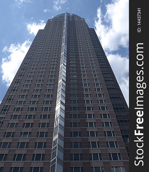 Messeturm in Franfkurt, modern corporate office building with scattered clouds in the background