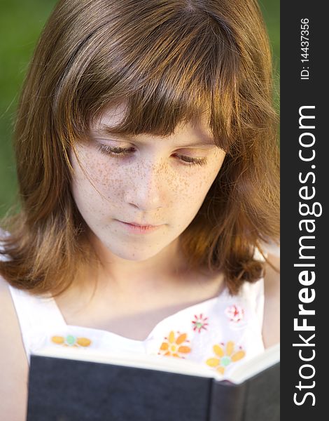 Young Beautiful Girl Reading A Book