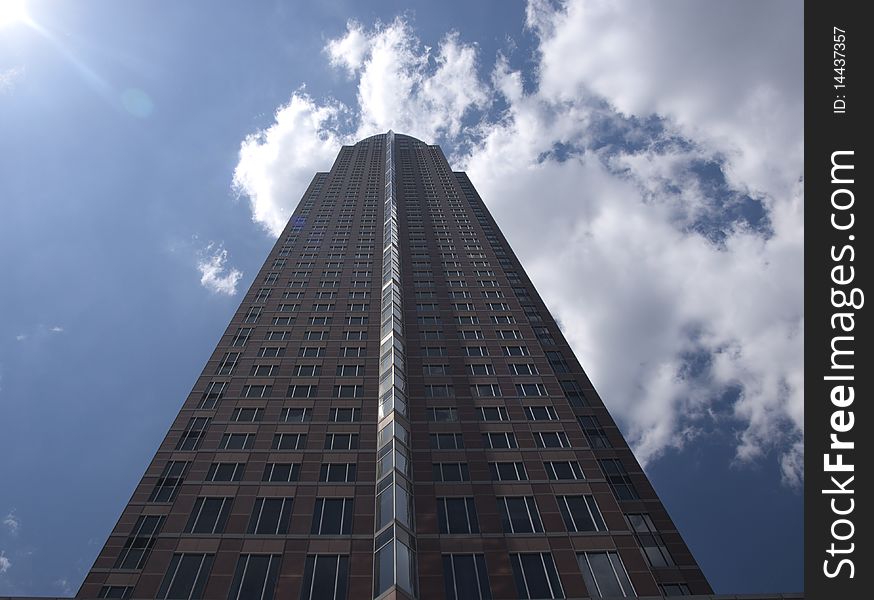 Messeturm in Frankfurt, modern corporate office building with scattered clouds in the background