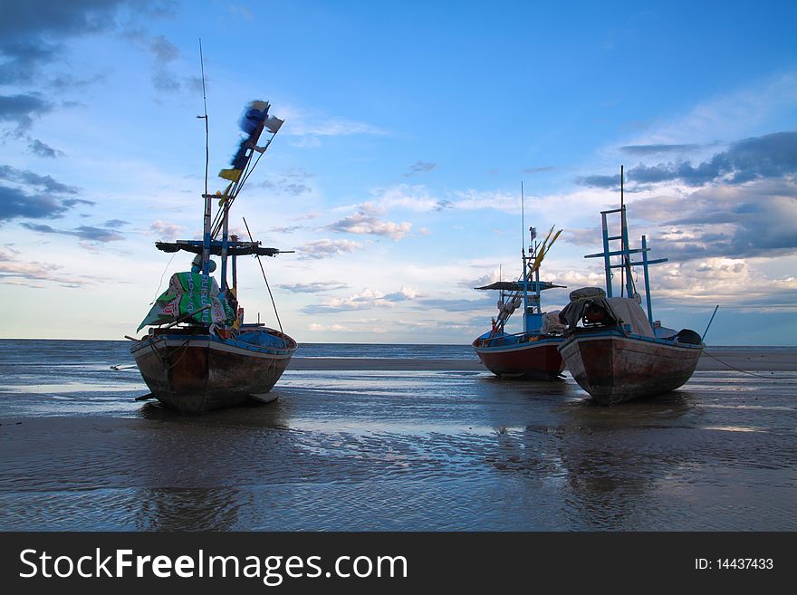 Three fishing boat rest on the beach