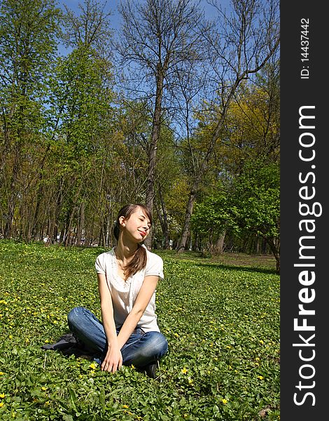 Girl sitting on the lawn in the park