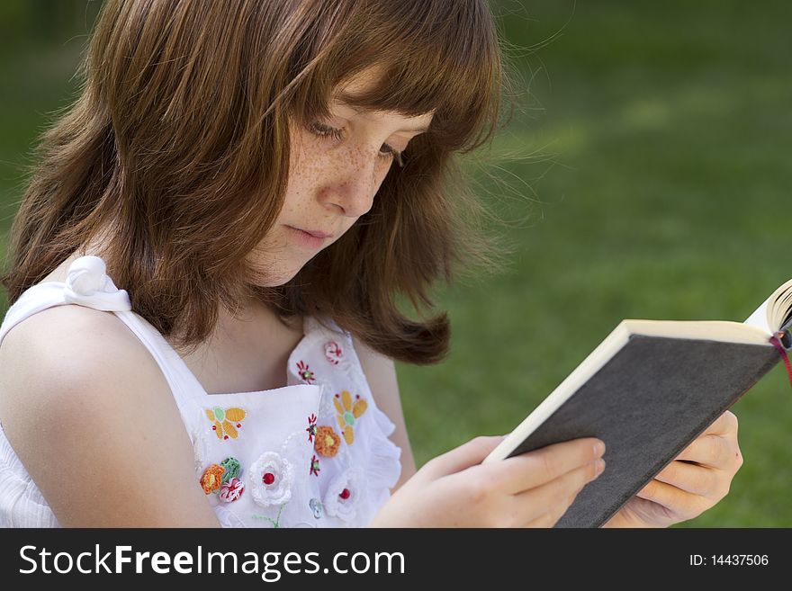 Young Beautiful Girl Reading A Book