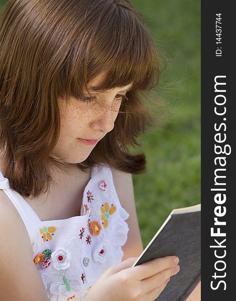 Young Beautiful Girl Reading A Book